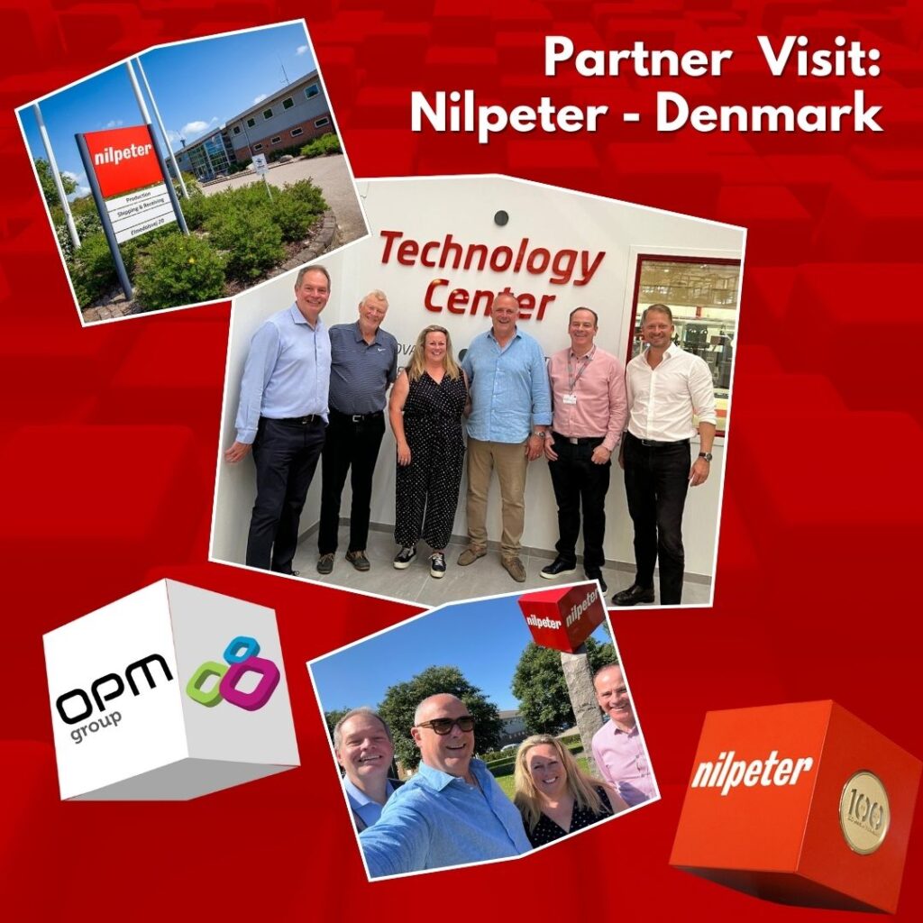 Pictures of OPM (Label & Packaging) Group's Managing Directors Susan Ellison & Chris Ellison and Value Stream Director Paul Smith visiting the Nilpeter Denmark site, akk iob a red background. www.opmgroup.co.uk, 0113 231 1000, sales@opmgroup.co.uk