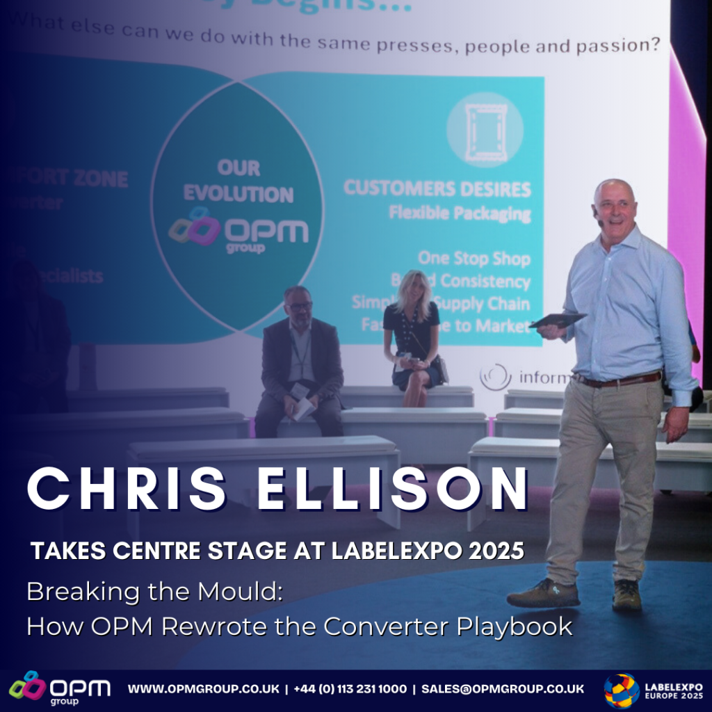 Chris Ellison takes center stage at Labelexpo 2025, presenting on how OPM rewrote the converter playbook. The image shows Chris Ellison standing with a tablet in hand, addressing an audience seated in front of a large screen displaying OPM Group's evolution and customer desires for flexible packaging. The backdrop highlights key points such as 'One Stop Shop,' 'Brand Consistency,' and 'Simplified Supply Chain.' Contact details for OPM Group and Labelexpo Europe 2025 are also visible.